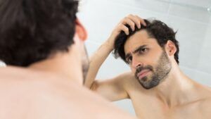 Hombre observando su línea capilar y valorando un injerto capilar.